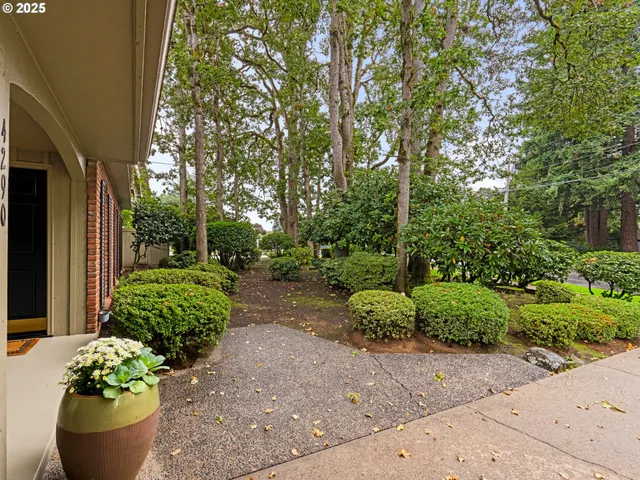 a front view of a house with a yard and potted plants