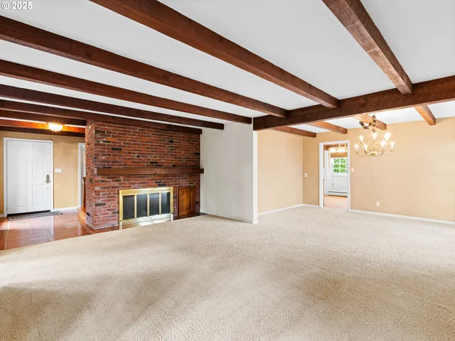 a view of an empty room with a fireplace and a window