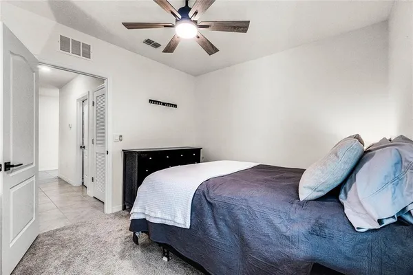 a spacious bedroom with a bed and a chandelier