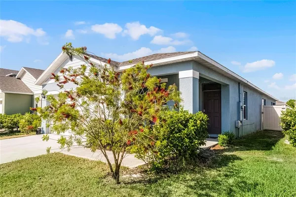 a yellow house with flower garden in front of it