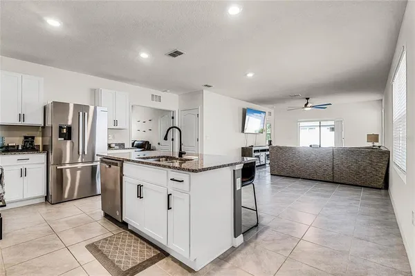 a kitchen with a sink a refrigerator and cabinets