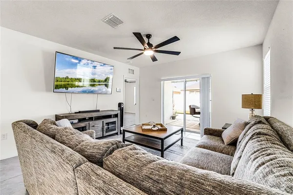 a living room with furniture a flat screen tv and a window