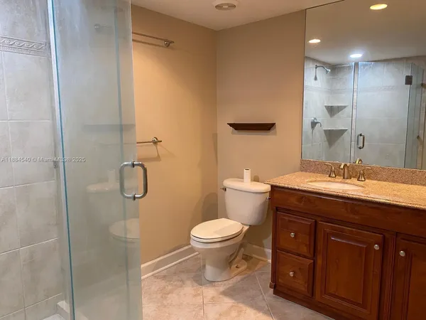 a bathroom with a granite countertop sink toilet and shower
