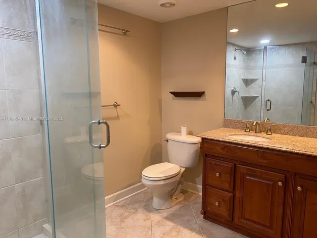 a bathroom with a granite countertop sink toilet and shower