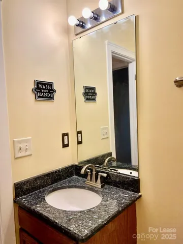 a bathroom with a granite countertop sink and a mirror