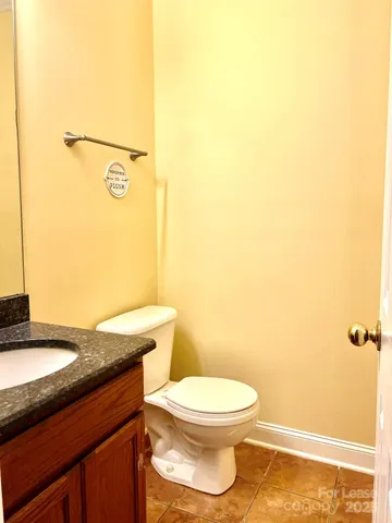 a bathroom with a granite countertop toilet and a sink