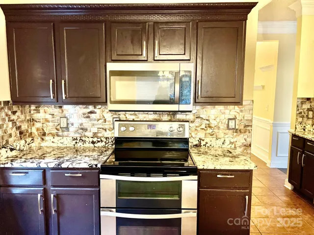 a stove top oven sitting inside of a kitchen