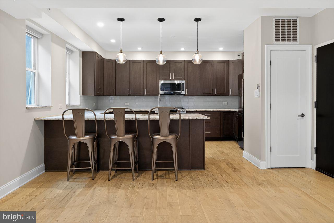 236 South 21st Street, Unit CD Philadelphia, PA 19103 - Photo 8 of 27 a kitchen with kitchen island cabinets and refrigerator