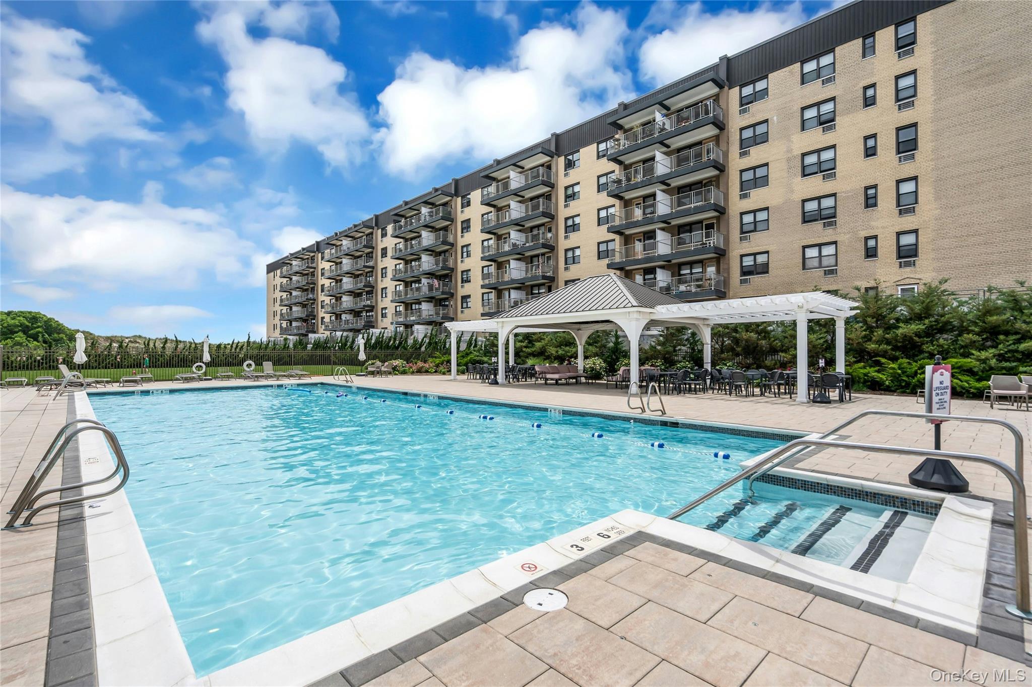 2 Richmond Road, Unit 5W Lido Beach, NY 11561 - Photo 17 of 42 Expansive outdoor pool area featuring a large swimming pool, and a surrounding paver patio