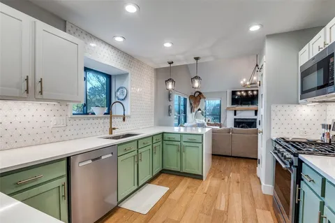 a kitchen with stainless steel appliances granite countertop a sink and a stove top oven