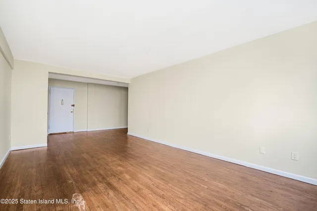 a view of an empty room and wooden floor