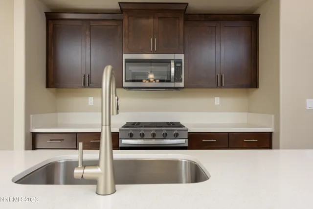 a kitchen with granite countertop a sink and a stove top oven