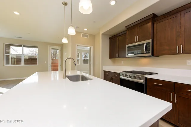 a kitchen with stainless steel appliances kitchen island granite countertop a stove a sink and a microwave