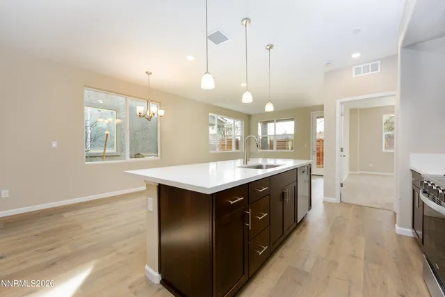 a large kitchen with stainless steel appliances granite countertop a large counter top a sink and a wooden floor
