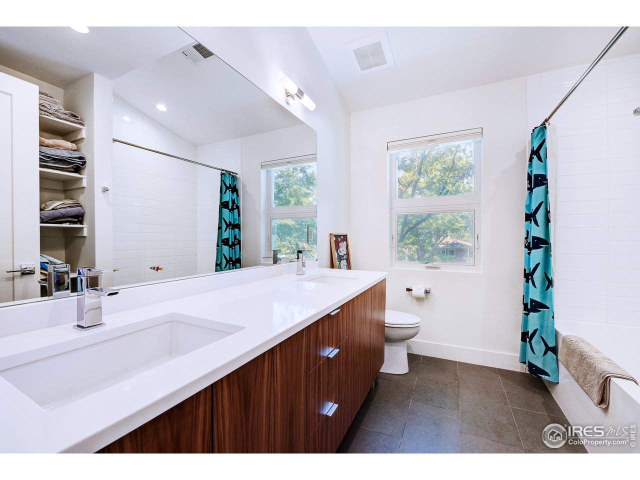 2930 18th Street Boulder, CO 80304 - Photo 26 of 40 a bathroom with a double vanity sink a large mirror and a shower