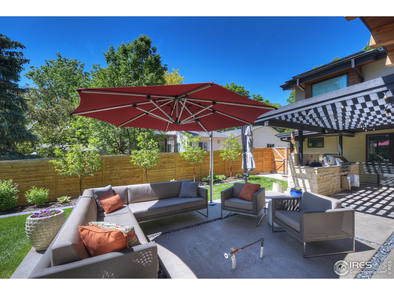 2930 18th Street Boulder, CO 80304 - Photo 35 of 40 a view of a patio with couches table and chairs under an umbrella with a fire pit