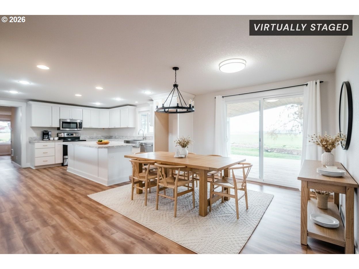 10471 Wagon Road Northeast Mount Angel, OR 97362 - Photo 6 of 48 a dining hall with stainless steel appliances kitchen island granite countertop a dining table chairs and a refrigerator