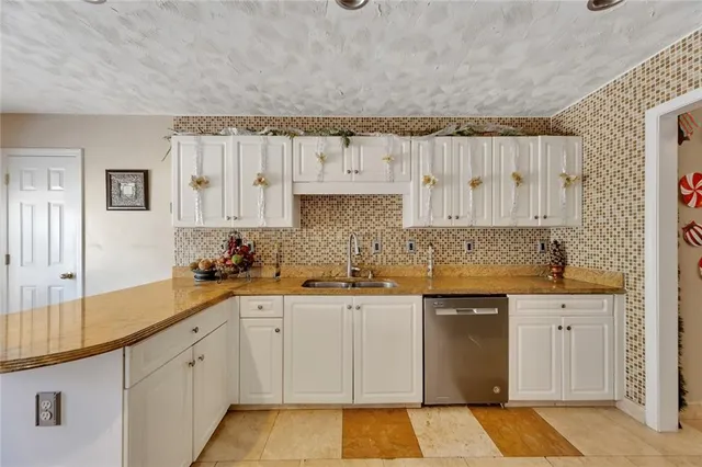a kitchen with granite countertop a sink and cabinets