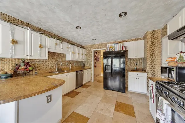 a kitchen with stainless steel appliances granite countertop a refrigerator stove and sink