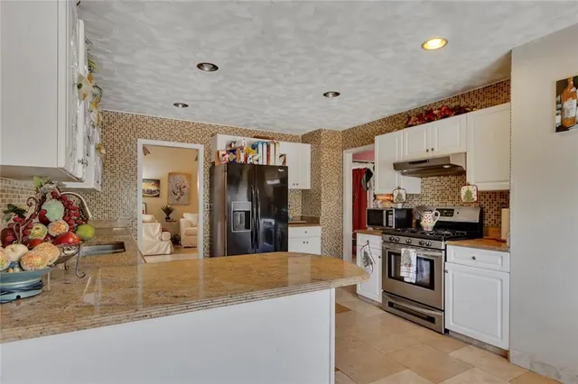 a kitchen with stainless steel appliances granite countertop a sink and cabinets