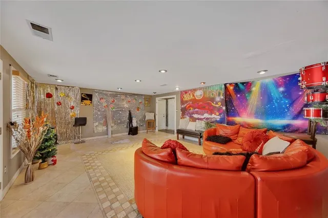 a living room with blue lights with furniture and a flat screen tv