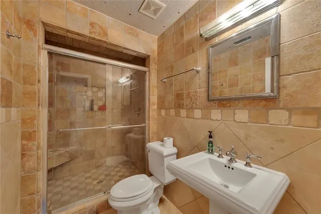 a bathroom with a sink mirror toilet and shower