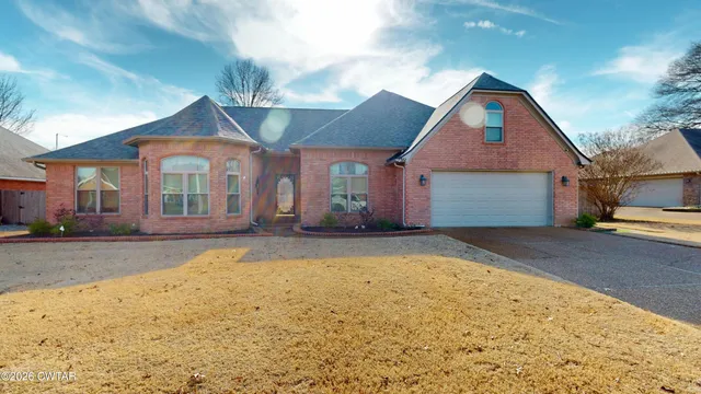 a view of an empty room with wooden floor fireplace and a window