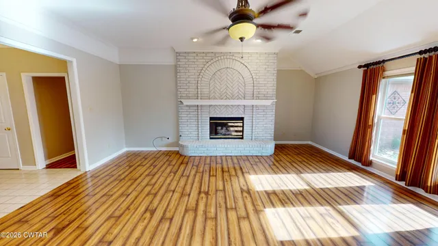 a view of a hallway with a white door and wooden floor