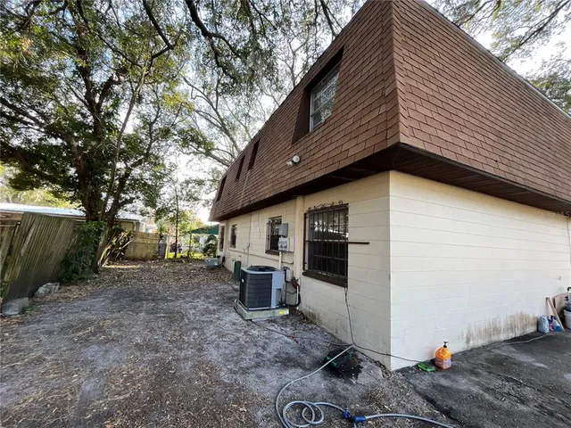 a backyard of a house with barbeque oven tree and wooden fence