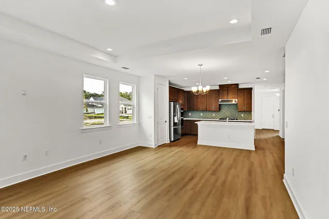 a large kitchen with wooden floors and stainless steel appliances