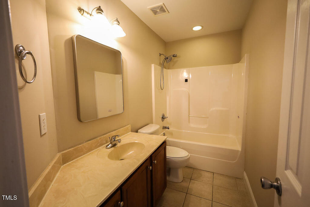 10 London Way Spring Lake, NC 28390 - Photo 20 of 26 a bathroom with a granite countertop sink a toilet and shower