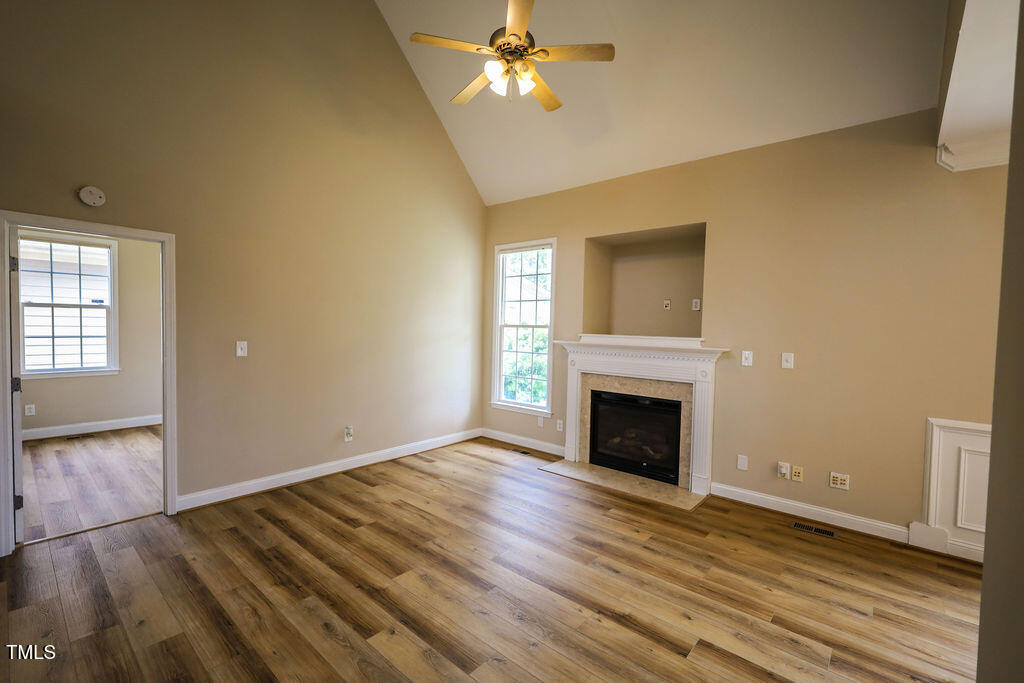 10 London Way Spring Lake, NC 28390 - Photo 8 of 26 an empty room with wooden floor fireplace and windows