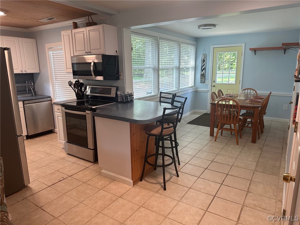 328 Cow Shed Road Lancaster, VA 22503 - Photo 11 of 27 a view of kitchen with cabinets stainless steel appliances and dining table
