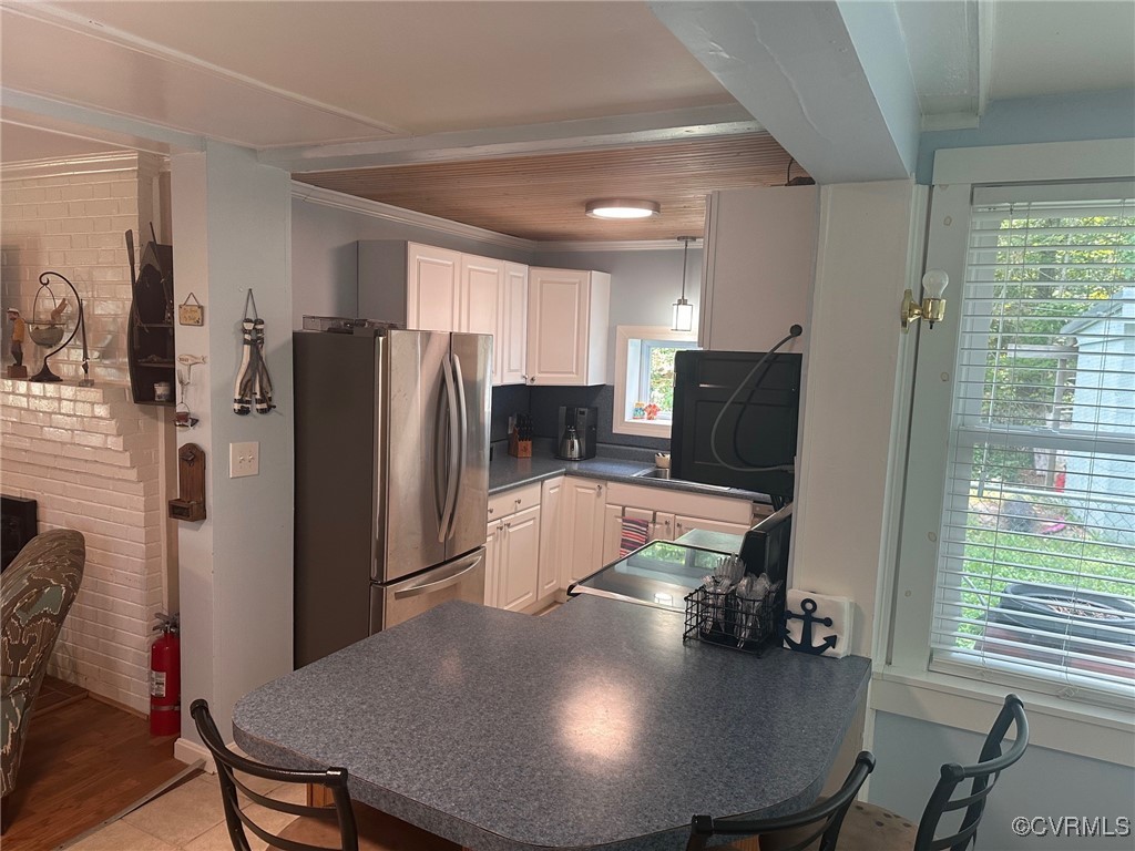 328 Cow Shed Road Lancaster, VA 22503 - Photo 12 of 27 a kitchen with stainless steel appliances granite countertop a refrigerator a stove a sink a dining table and chairs