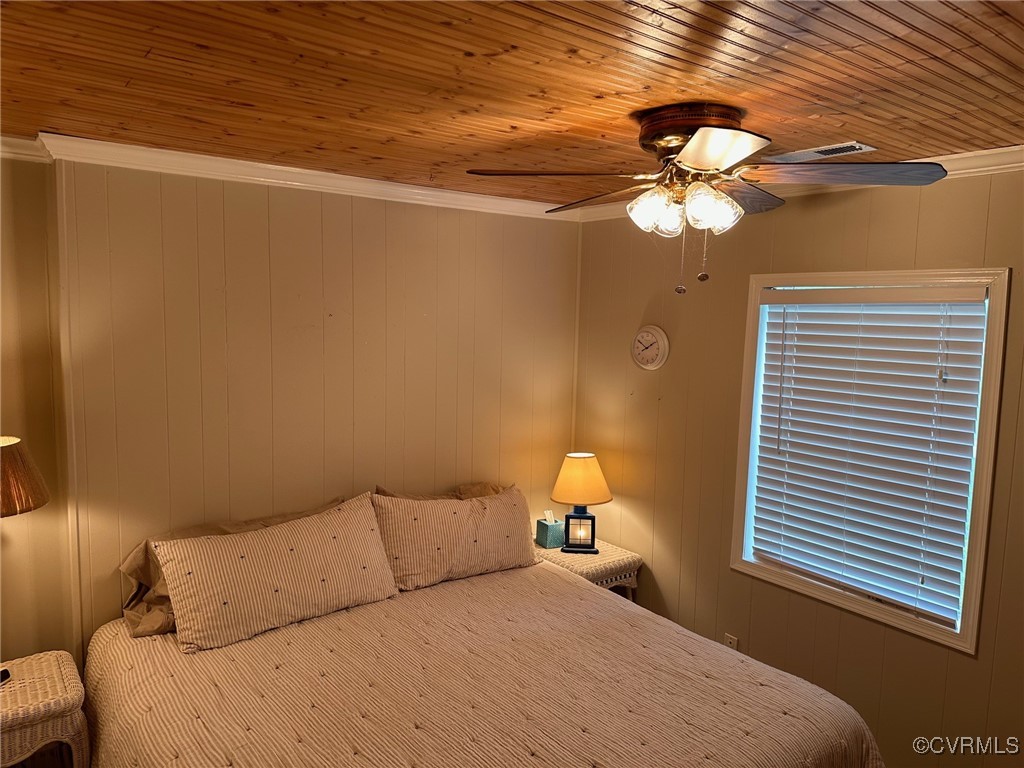 328 Cow Shed Road Lancaster, VA 22503 - Photo 14 of 27 a bedroom with a bed and a chandelier