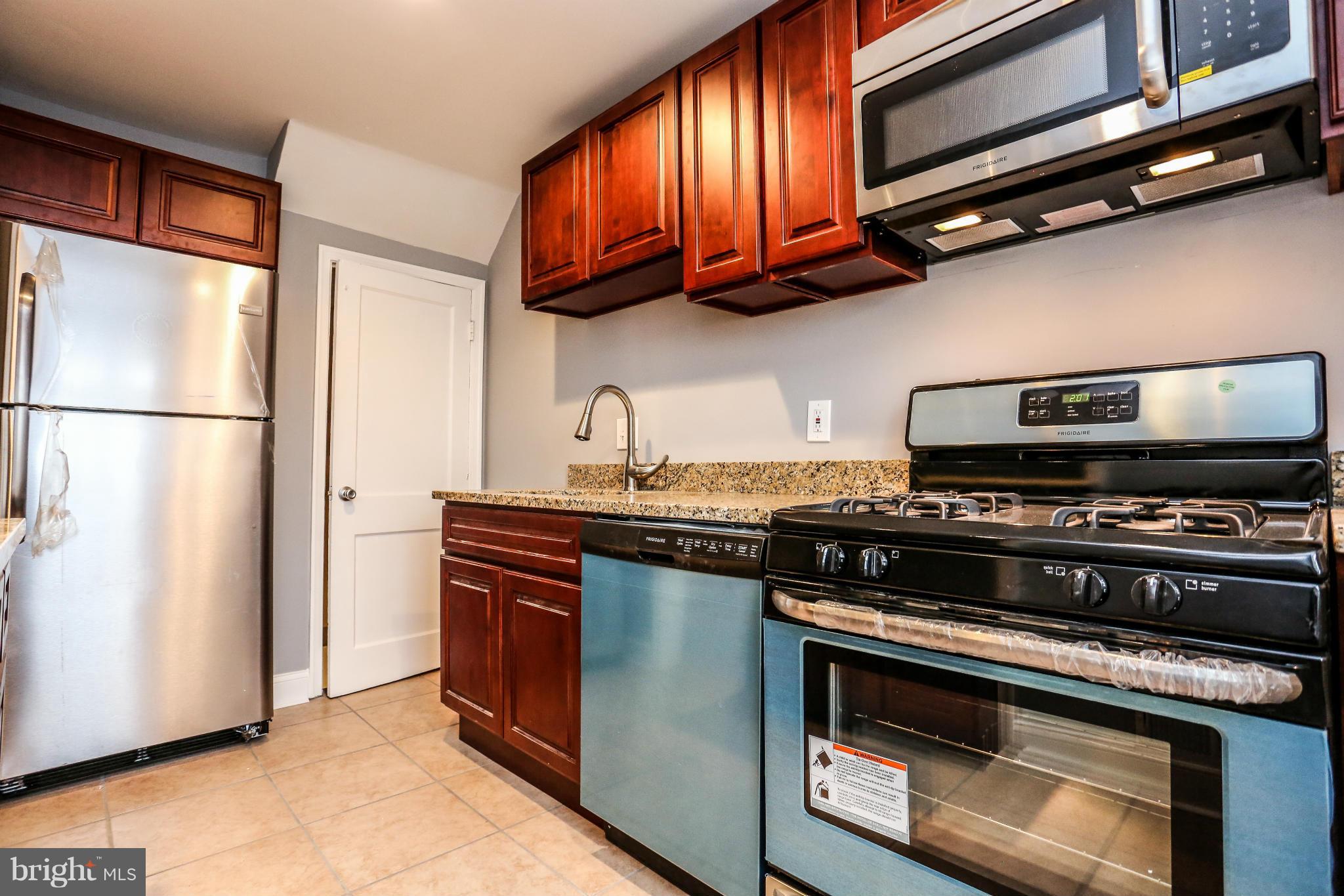 8163 Kavanagh Road Dundalk, MD 21222 - Photo 8 of 21 a kitchen with stainless steel appliances granite countertop a stove and a refrigerator