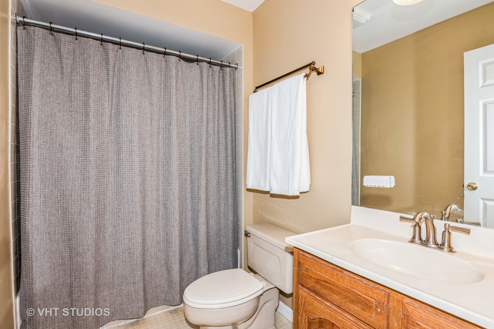 1057 Ponca Drive Batavia, IL 60510 - Photo 16 of 23 a bathroom with a sink a toilet and shower curtain