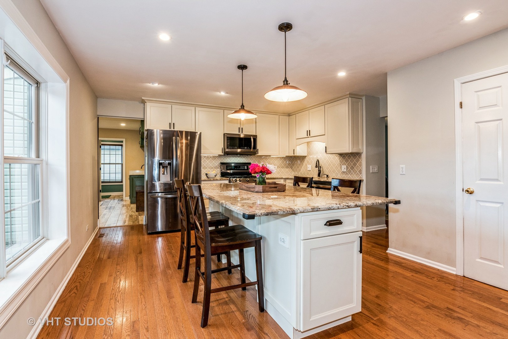 1057 Ponca Drive Batavia, IL 60510 - Photo 6 of 23 a kitchen with stainless steel appliances kitchen island granite countertop a stove a refrigerator a oven a sink a dining table and chairs with wooden floor