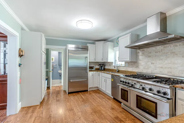 a kitchen with wooden floors and stainless steel appliances