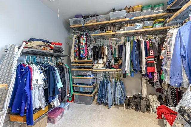 a view of walk in closet with clothes and shoes