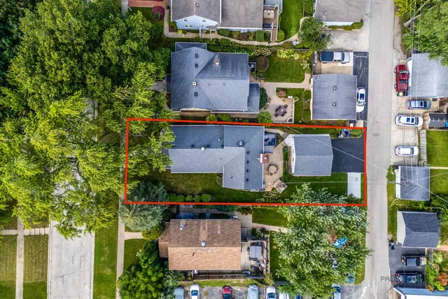 an aerial view of residential houses with outdoor space and parking