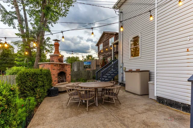 a view of a patio with a table and chairs and a barbeque