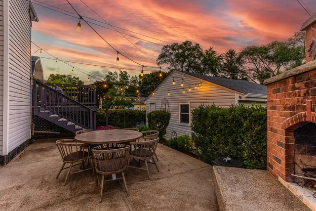 a patio with table and chairs and potted plants