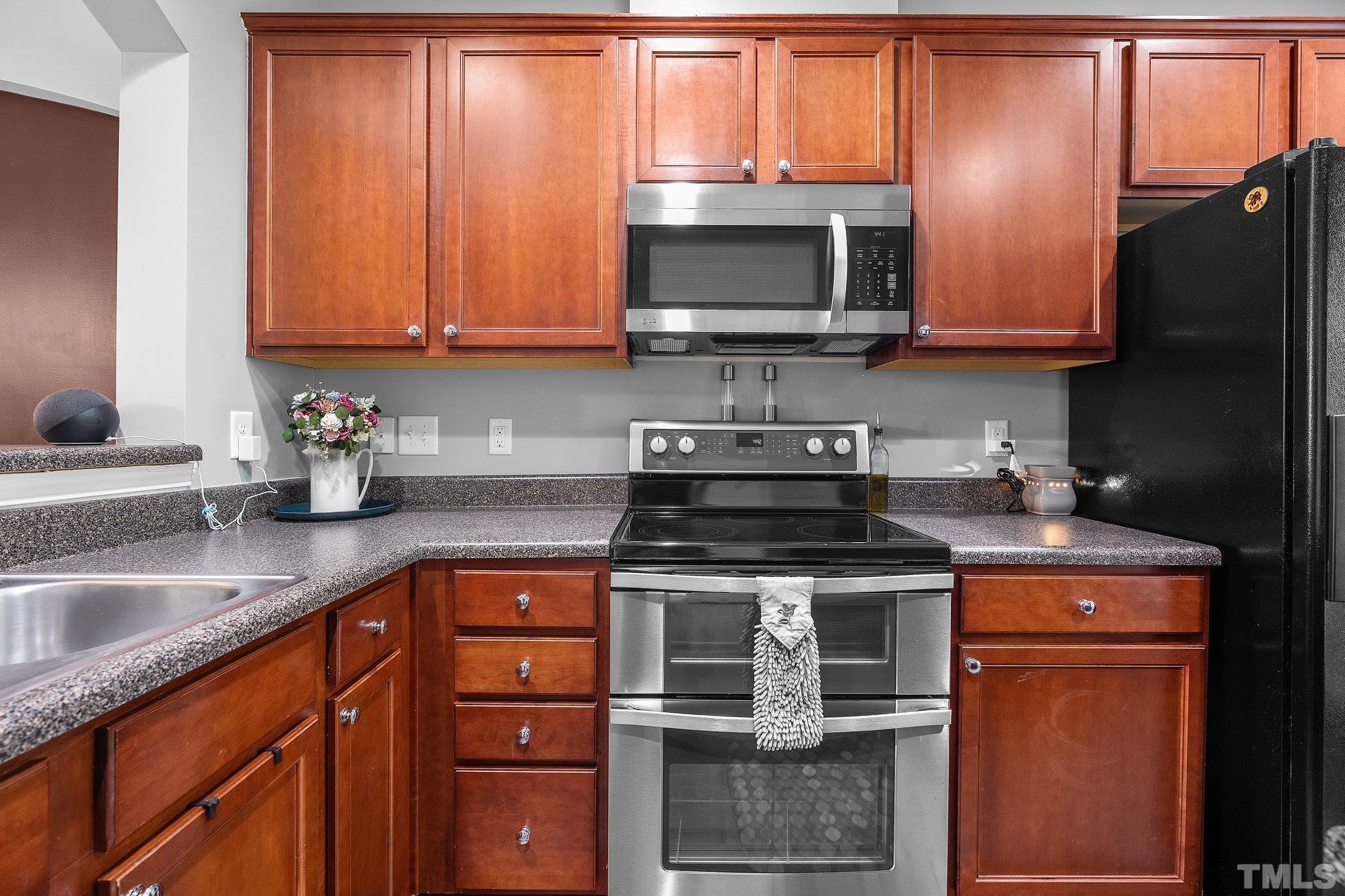 8564 Quarton Drive Raleigh, NC 27616 - Photo 12 of 28 a kitchen with stainless steel appliances granite countertop a stove microwave refrigerator and sink