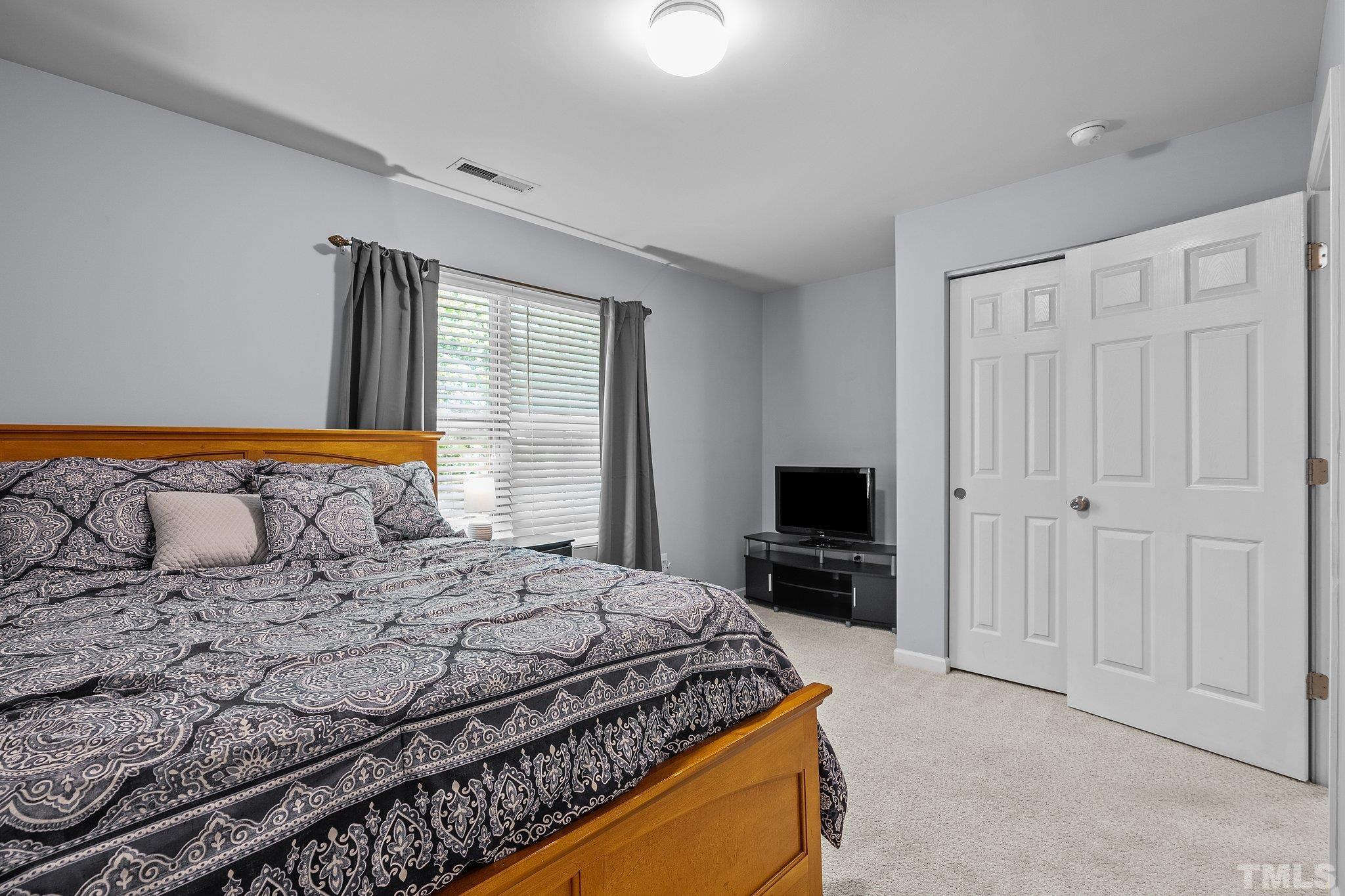 8564 Quarton Drive Raleigh, NC 27616 - Photo 21 of 28 a bedroom with a bed and a flat screen tv