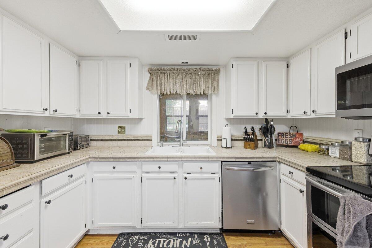 650 Sarah Lane Eagle Point, OR 97524 - Photo 10 of 19 a kitchen with granite countertop white cabinets white stainless steel appliances with a sink and dishwasher