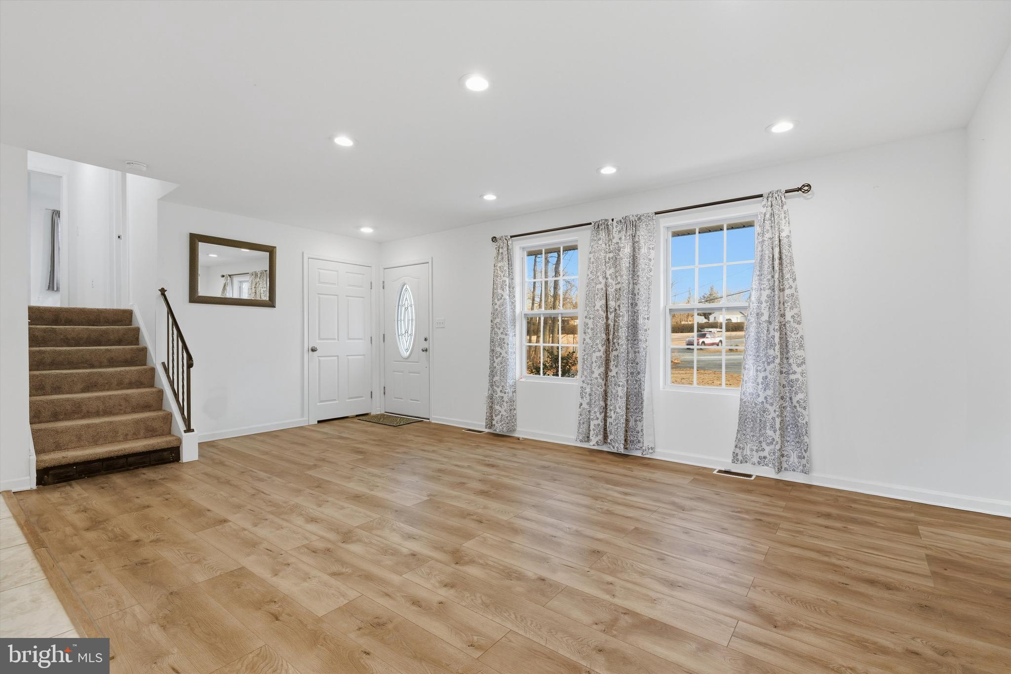 7428 Hawkins Drive Hanover, MD 21076 - Photo 12 of 44 a view of an empty room with wooden floor and stairs