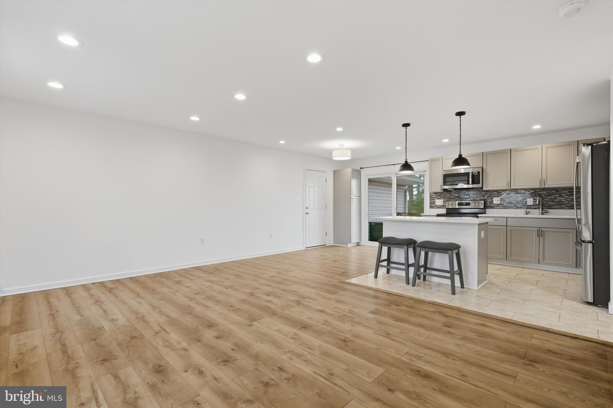 7428 Hawkins Drive Hanover, MD 21076 - Photo 15 of 44 a open kitchen with kitchen island white cabinets and stainless steel appliances