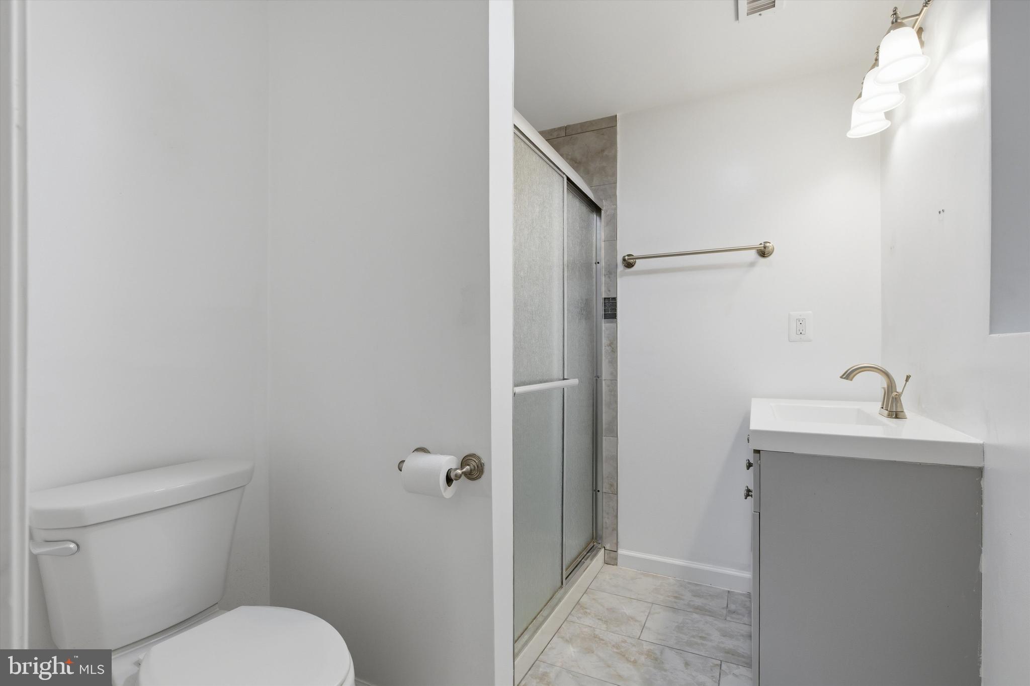 7428 Hawkins Drive Hanover, MD 21076 - Photo 20 of 44 a bathroom with a toilet sink a shower and mirror