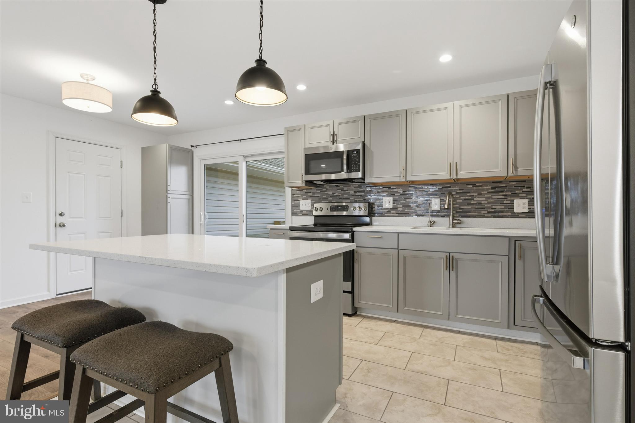 7428 Hawkins Drive Hanover, MD 21076 - Photo 10 of 44 a kitchen with a stove cabinets and chairs
